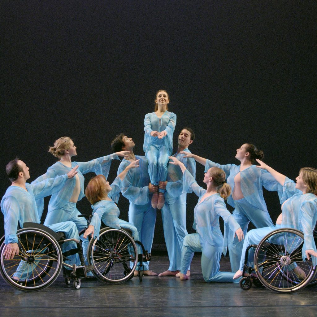 Dancers with and without disabilities pose around a dancer who is signing the letter H for Helen in Helen Keller: A Tribute to Her Teacher