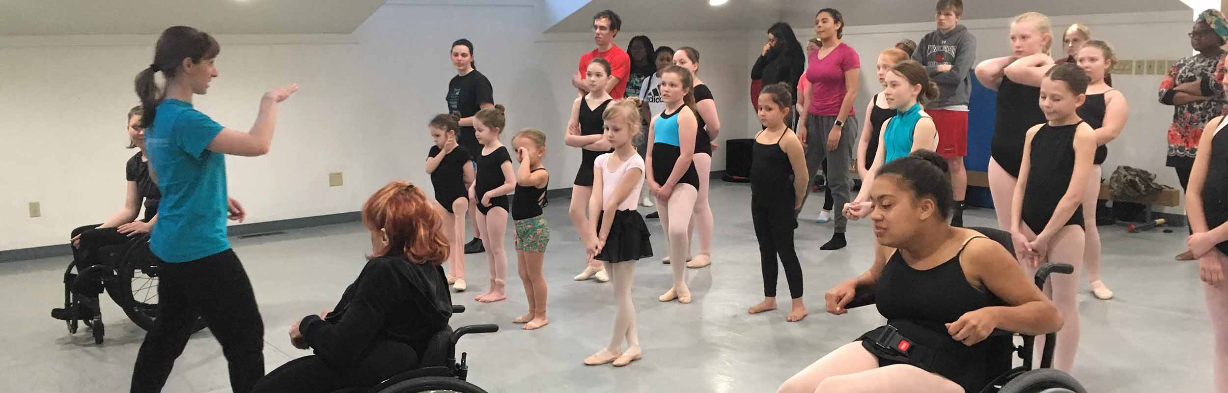 Dance teaching artists with and without disabilities leading a workshop class for students of all ages and abilities.