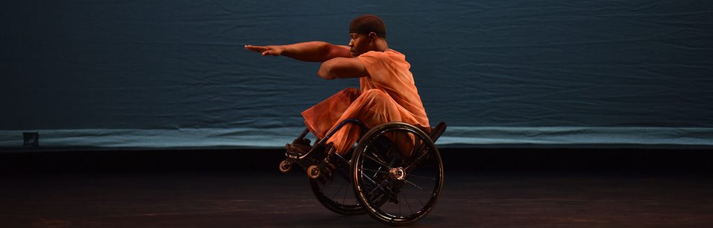 Dancer DeMarco does a wheelie trick in his wheelchair with no hands
