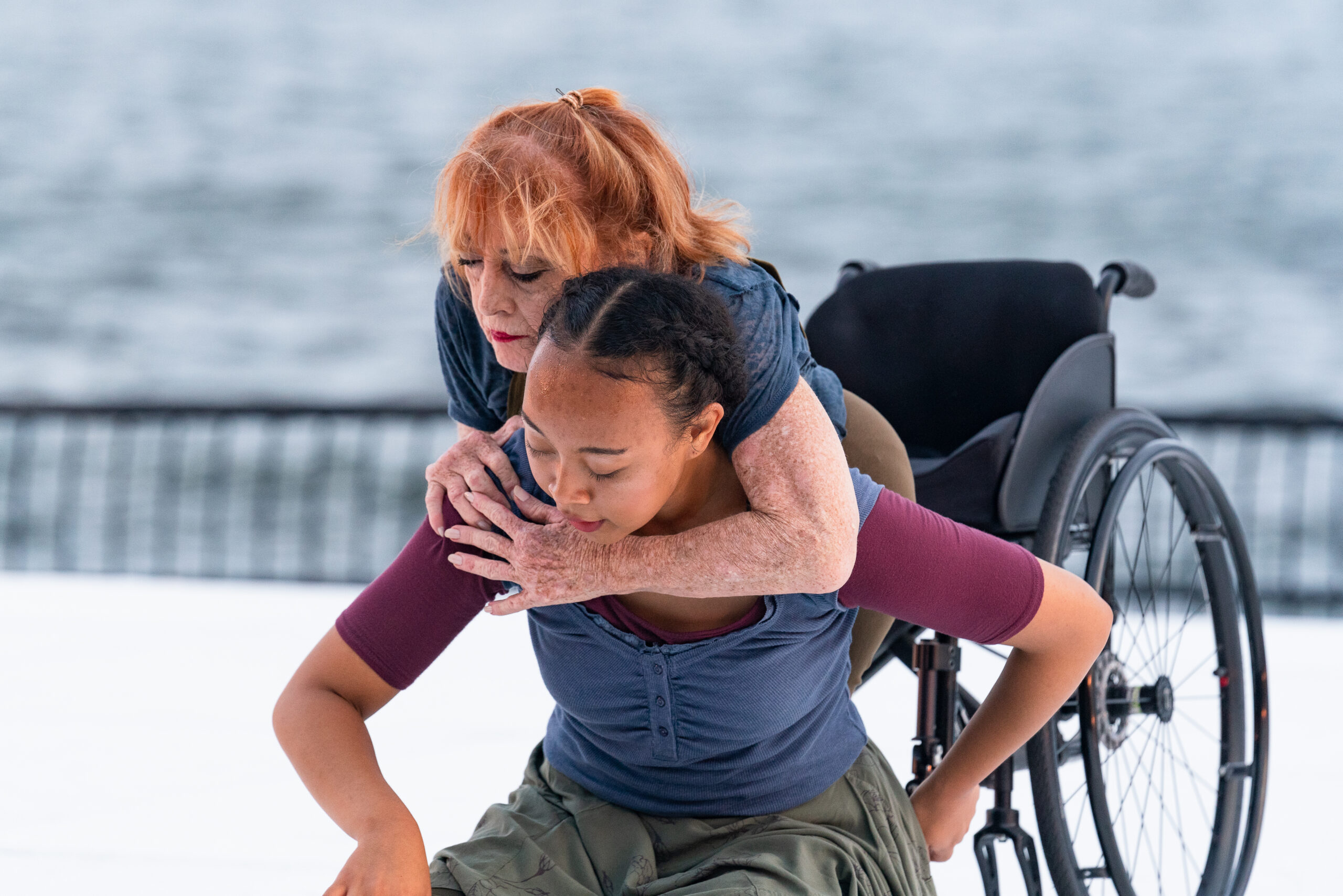 A dancer with a disability and a dancer without a disability holding onto each other